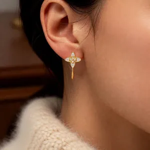 Elegant C-shaped gold clover earrings with sparkling cubic zirconia on female model