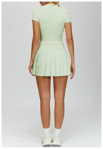 Back view of mint green pleated tennis skirt and slim fit short sleeve athletic top