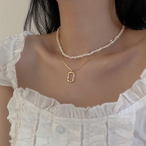 Close-up of double layer necklace with freshwater pearls and gold rectangular pendant