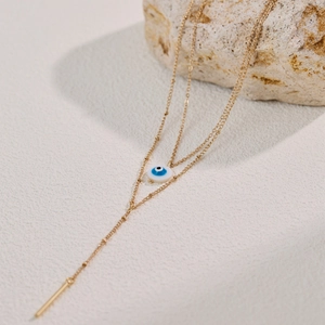 Layered gold evil eye necklace with blue enamel pendant and elegant long tassel charm