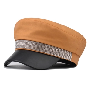 Detail of bright orange cotton military cap with rhinestone band and black leather brim
