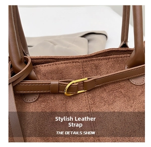 Detailed close-up of brown suede tote bag with golden buckle and precision stitching