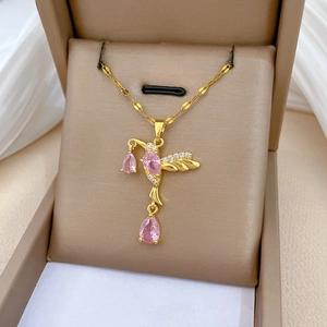 Detailed view of hummingbird pendant with pink zircon stones in a jewelry box