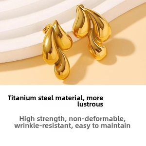 Close-up of polished gold triple teardrop earrings made of durable titanium steel