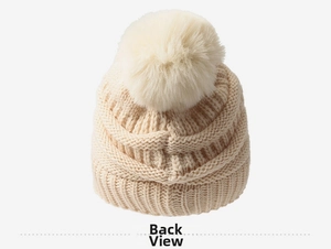 Détail de l'arrière d'un bonnet en maille torsadée beige avec pompon en fausse fourrure