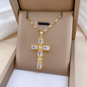 Vue macro du pendentif croix dorée serti de zircons dans son écrin à bijoux