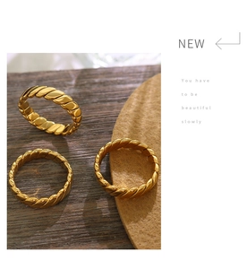 Detailed close-up of 18K gold plated twisted rope ring with elegant metallic texture