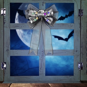 Halloween skull print bow tie with LED lights hanging on a vintage window against moonlight