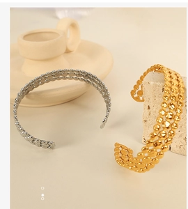 Detailed view of gold and silver open bangles featuring triple-row dot textures