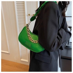 Detail of green crescent shoulder bag with chunky gold chain and braided satin strap