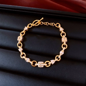 Detailed macro view of gold-plated OT buckle bracelet with square and pear-cut zircons