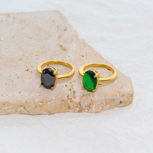 Golden stainless steel rings with oval black and green zircon gemstones on stone base