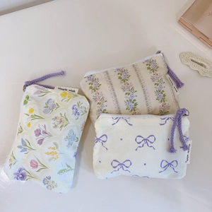 Detailed view of floral canvas coin purses with purple zip pullers and simple wish tags