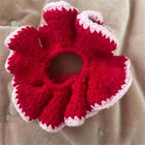 Detail of handmade crochet hair scrunchie with red and white knitted wavy flower texture