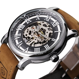 Detail of mechanical skeleton watch with roman numerals and brown leather strap