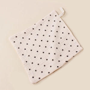 Detail of square muslin baby washcloth with star patterns and hanging strap loop