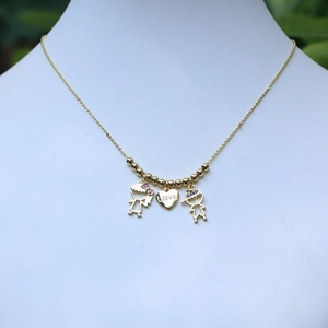 Gold couple necklace with boy, girl, and heart pendant on jewelry display stand