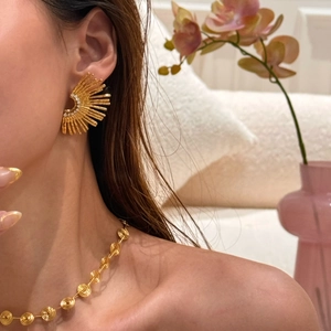 Detail of 18k gold plated vintage sunburst earrings and necklace on a model