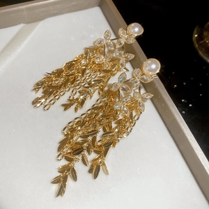 Detailed close-up of floral tassel earrings with 18K gold plating, pearls and rhinestones