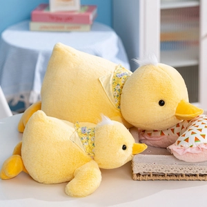 Plush yellow duck stuffed toy set with floral scarves in a cozy home setting