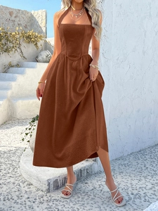 Detail of a brown halter-neck A-line maxi dress featuring textured fabric for summer vacation