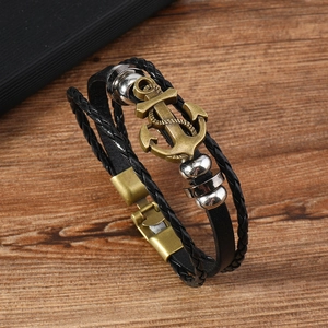 Men's retro multi-layer braided leather bracelet with bronze anchor charm on wood background