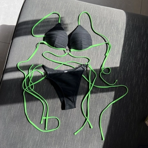 Sultry two-tone ribbed bikini set with metal ring accent and fluorescent green ties