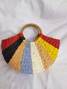 Detail of bohemian colorful woven handbag showing seven-color radial stitching and circular handles