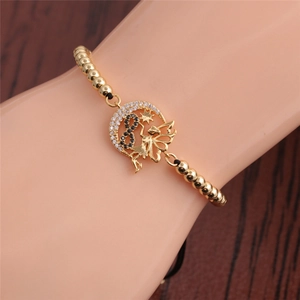 Adjustable gold bead bracelet with zircon moon, star, and fairy charms on wrist