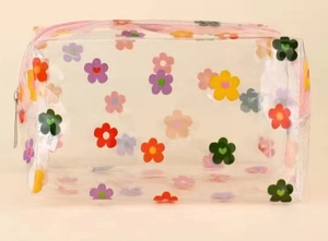 Detail shot of a transparent PVC makeup bag featuring colorful floral patterns and silver zipper