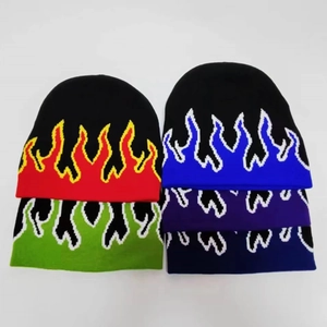 Detail shot of knitted beanies featuring flame jacquard patterns in five vibrant colors