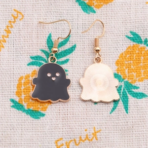 Detailed close-up of cartoon ghost earrings showing black enamel front and gold metal back