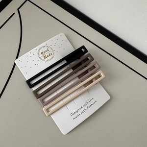 Set of four matte rectangular non-marking hair clips in neutral earth tones on a card
