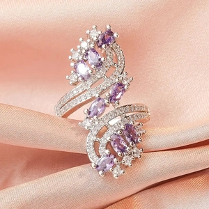 Detail of luxury ring featuring purple oval gemstones and sparkling zircon on satin