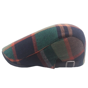 Detail of plaid beret showing adjustable metal buckle and multi-color checkered fabric