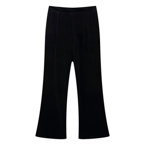 Détail d'un pantalon évasé noir à taille haute en velours lisse avec un éclat subtil