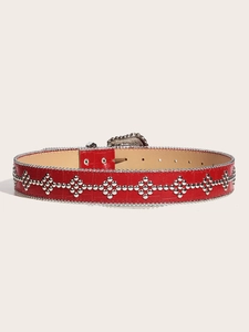 Detail of red crocodile pattern leather belt with silver rivets and vintage engraved buckle
