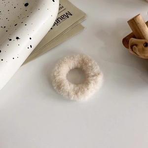 Dettaglio dell'elastico per capelli in peluche bianco sporco su tavolo decorato