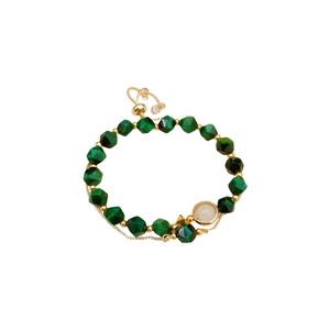Green tiger eye beaded bracelet with adjustable gold clasp and white pendant on white backdrop