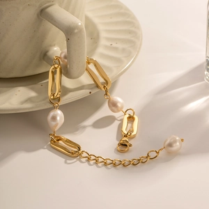Close-up of baroque pearls and 18K gold plated links on a hanging chain bracelet