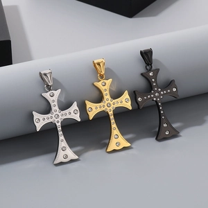 Detailed close-up of three iced-out cross pendants in silver, gold, and black steel
