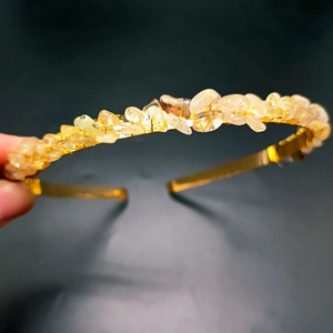 Close-up of handmade gold metal headband with translucent yellow crystals and wire wrapping