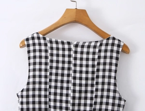 Detail of invisible back zipper and black and white plaid texture on sleeveless dress