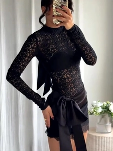 Détail d'un haut élégant en dentelle noire avec un grand nœud en satin dans le dos
