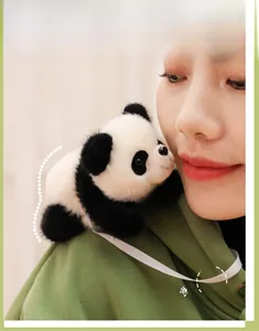 Detail of cute plush panda with magnetic attachment feature on a soft shoulder strap