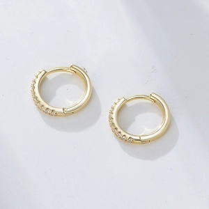 Macro detail of gold S925 silver hoop earrings with micro-pave white cubic zirconia stones
