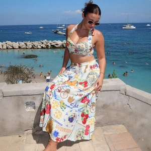 Two-piece floral vacation set with halter crop top and high-waist skirt on a yacht