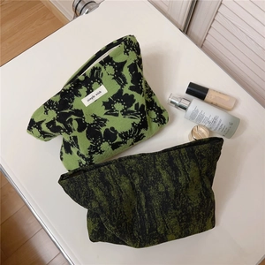 Detail of vintage green floral jacquard canvas makeup bags with zip closure and fabric label