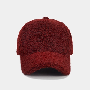Detailed texture of dark red fluffy lamb wool baseball cap with thick fleece material