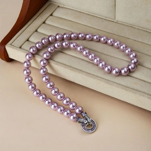 Detailed view of luxury purple pearl necklace with crystal inlaid silver clasp